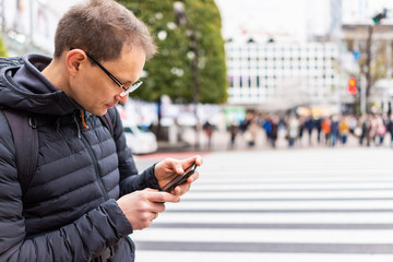 Tokyo, Japan famous Shibuya crossing in downtown city with man tourist standing looking at...