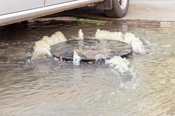Accident sewerage system. Water flows over the road from the sewer. Water flows over the road from...