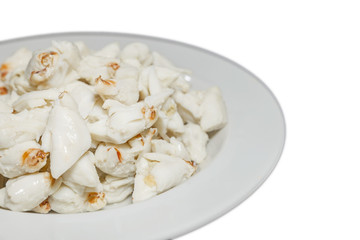 Top view of pile of fresh steamed crab meat without shell and ready to eat on white dish isolated on white background.