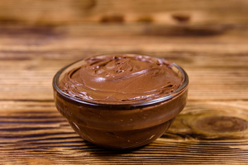 Glass bowl with chocolate spread on a wooden table