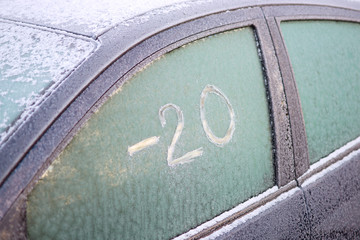Frozen car window with scratched text on the ice: 