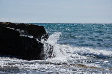 Traveling to the sea, a wave rolls over stones.