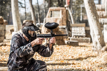 A man with a gun playing paintball.