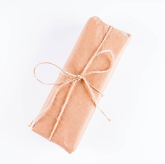 Gift decorated with a gunny string bow on a white background