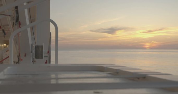 Sunset in open sea, view from open deck of moving cruiser ship, timelapse.