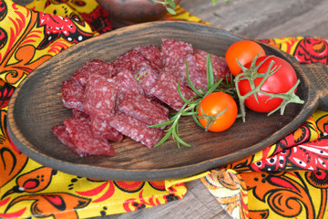 Salami sausage on wooden cutting board in khokhloma style