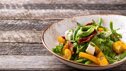 Tasty autumn salad with pumpkin,  asparagus, lettuce, dried tomatoes and cheese. Copy space