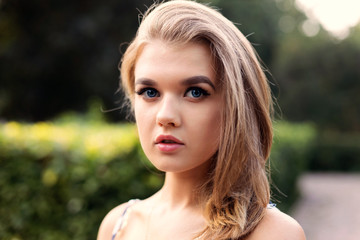 Naklejka premium Closeup portrait of a young attractive girl against blurred background. Shallow focus.