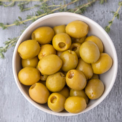 Green olives on grey background. Top view