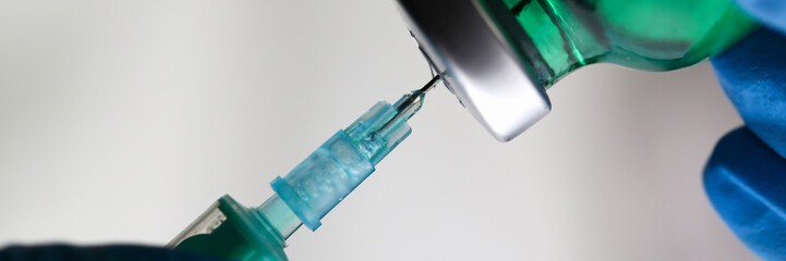 Physician injector arms in sterile uniform holding syringe