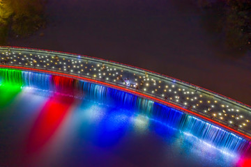 Aerial view of Starlight Bridge or Anh Sao Bridge which is a pedestrian bridge with colored lights and waterfall in District 7 of Ho Chi Minh City also known as Saigon, Vietnam. 