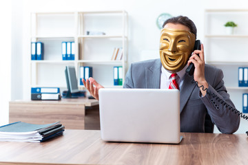 Businessman wearing mask in hypocrisy concept