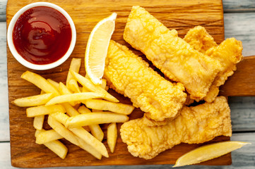 fish and chips with french fries, on wooden background 