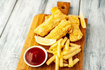 fish and chips with french fries, on wooden background 