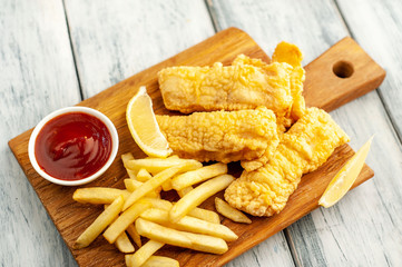 fish and chips with french fries, on wooden background 