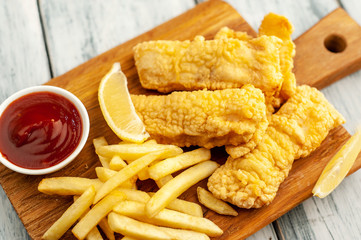 fish and chips with french fries, on wooden background 