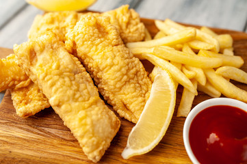 fish and chips with french fries, on wooden background 