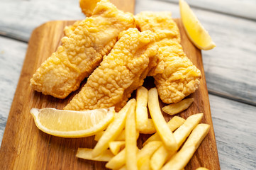fish and chips with french fries, on wooden background 
