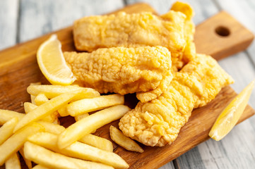 fish and chips with french fries, on wooden background 