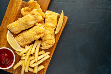fish and chips with french fries, on a stone background with copy space for your text