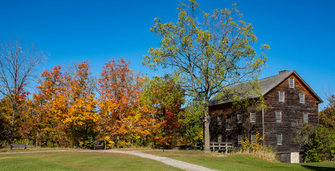 Fototapeta na wymiar Colorful Fall Foliage and an Old Mill Building in Rural Ontario