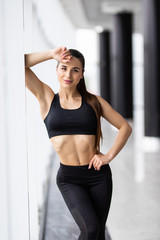 Sporty muscular fitness woman standing in gym. Health concept.