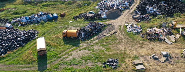 Aerial drone perspective view on car junkyard with old destroyed cars and old rusted parts waiting for recycling.
