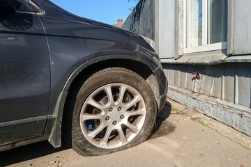 a traffic accident on a city street, a car with a broken and empty tire