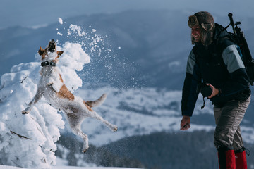 Lone trekker with his dog in snow.
