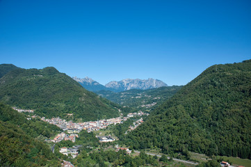 Fototapeta na wymiar little town at the foot of mountain range: Piccole Dolomiti - Italy
