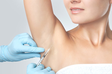 Obraz na płótnie Canvas The doctor makes intramuscular injections of botulinum toxin in the underarm area against hyperhidrosis. Cosmetology skin care