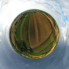 Aerial drone 360 degree panoramic view on agricultural landscape with wheat field, village, meadows, forest and rain storm on horizon.