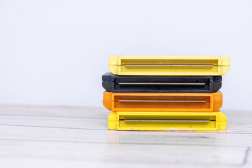 Old gaming cassettes on a wooden white table. Text space.