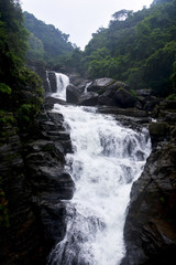 Close up of waterfall in Shillong in motion blurr  and rocks, selective focusing