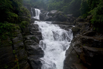 Close up of waterfall in Shillong in motion blurr  and rocks, selective focusing