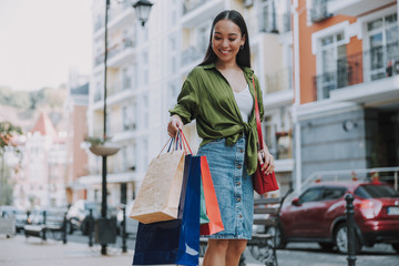 Pretty smiling woman looking on bags outdoors