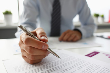 Hand of businessman in suit filling and signing with