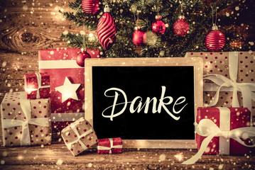 Obraz na płótnie Canvas Blackboard With German Text Danke Means Thank You. Christmas Tree With Decoration Like Ball, Gifts Or Presents, Snowflakes