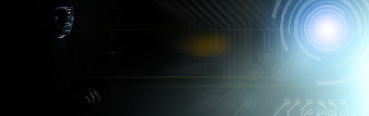 A man in a mask prints on the keyboard in the dark