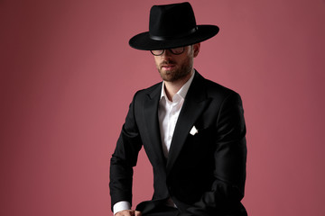 Confident mysterious man leaning on his leg