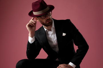 Curious groom looking away and leaning on his leg