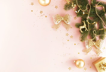 Christmas background. Xmas or new year gold color decorations on pink background with empty copy space for text.  holiday and celebration concept for postcard or invitation. top view 