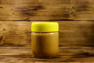 Jar of peanut butter on a wooden table
