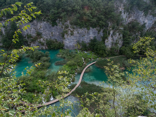 Croatia, august 2019: Tourists on the wooden park pathways enjoying the view of emerald lakes, cascades and crystal clear water, Plitvice Lakes National Park