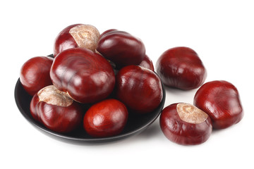 chestnuts in a black plate isolated on white background