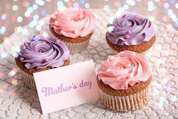 Tasty cupcakes with card for Mother's day on plate