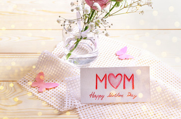 Flowers and handmade card for Mother's Day on wooden table