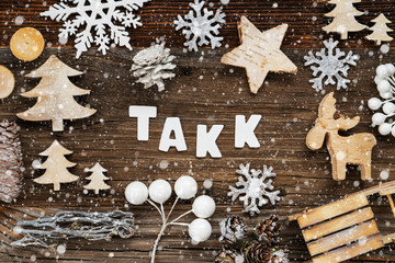 Obraz na płótnie Canvas White Letters Building The Word Takk Means Thank You. Wooden Christmas Decoration Like Tree, Sled And Star. Brown Wooden Background With Snowflakes