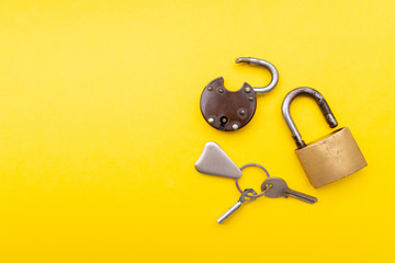 Old padlock and key on a yellow background. Copy space