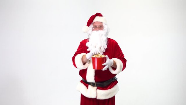 Christmas. Santa Claus on a white background with a red bucket with popcorn. There is popcorn, watching movies, emotions, fear, fun.